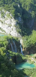 Lush green landscape with a waterfall cascading down rocky cliffs.