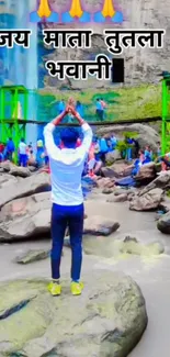 Man praying at scenic waterfall with lush greenery.