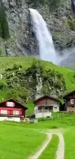 Charming village below stunning waterfall with lush green landscape.