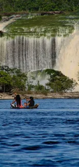 Boaters on river with lush waterfall backdrop.