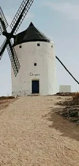 Rustic landscape with a charming windmill under a clear blue sky.