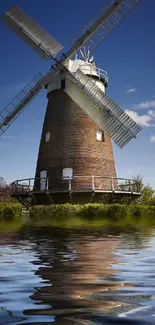 Picturesque windmill by the water under a clear blue sky.