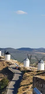 Landscape with windmills under a blue sky.