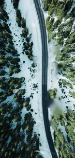 Aerial view of a snowy forest road with evergreen trees on a mobile phone wallpaper.