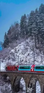 Winter train crossing snowy bridge with sky blue backdrop.