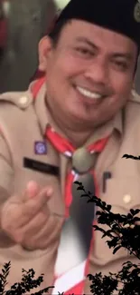 Smiling scout leader in uniform making a heart gesture outdoors.