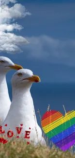 Seagulls with rainbow heart under a blue sky with clouds.