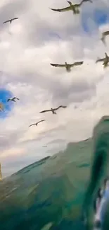 Seagulls fly over ocean waves with a cloudy sky background.