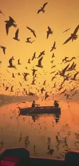 Seagulls fly over boats during an orange sunset.