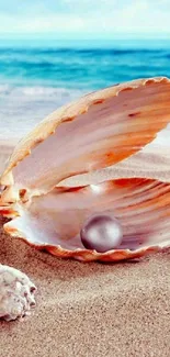 Open seashell with pearl on sandy beach, ocean in background.