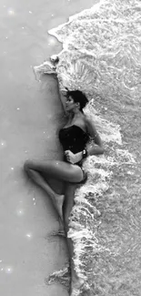 A peaceful beach scene in black and white with gentle waves and a relaxed figure.