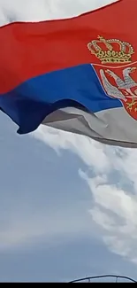 Serbian flag waving against a blue sky.