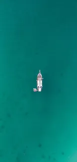 Aerial view of a boat on a teal ocean background.