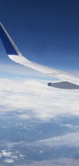 Airplane wing soaring above clouds and blue sky.