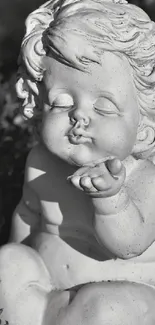 Black and white angelic cherub sculpture blowing a kiss.