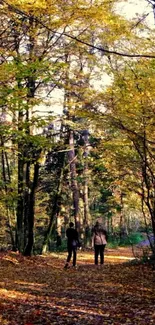 Two people walking in a serene autumn forest path with vibrant yellow leaves.