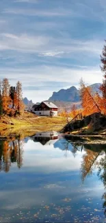 Autumn trees reflecting in a lake with a blue sky and mountain backdrop.