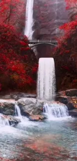 Waterfall amidst vibrant red autumn foliage under a bridge.