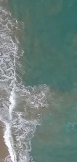 Aerial view of beach with foamy waves and turquoise ocean water.