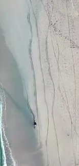 Aerial view of a tranquil beach with sandy shores and azure water.