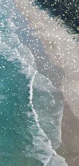 Aerial view of a turquoise beach with sparkling water and sandy shore.