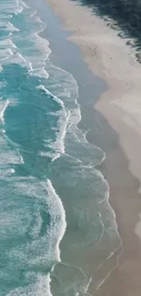 Aerial view of turquoise waves on a serene beach coastline.