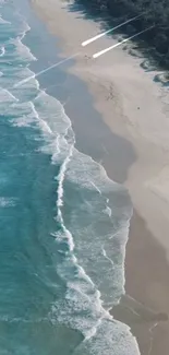 Aerial view of a serene beach with turquoise waves and sandy shore.