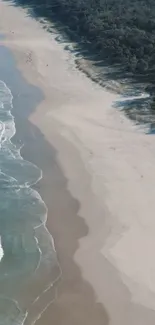 Aerial view of a serene beach with waves gently hitting the sandy shore.