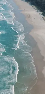 Aerial view of turquoise ocean waves and sandy beach shoreline.