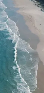 Aerial view of a serene beach with waves gently reaching the shore.