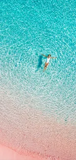 Aerial view of a turquoise beach with a person floating.