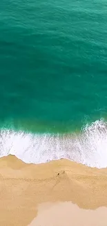 Aerial view of turquoise ocean waves hitting a sandy beach.