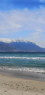 Serene beach and mountains under a bright blue sky.