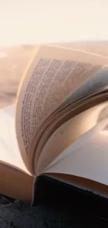 Open book by the beach with a serene sandy background.