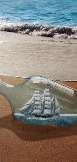 Bottle with ship on sandy beach by the ocean waves.