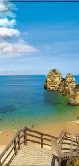 Scenic beach with cliffs and azure ocean under a bright blue sky.