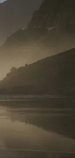 Horseback rider on misty beach with mountains in the background.