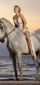 Woman on a white horse by the beach at sunset.