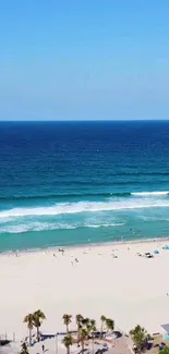 Scenic beach view with clear skies and turquoise ocean waves.