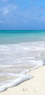 Serene beach with blue sky and gentle ocean waves.