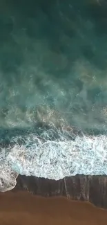 Aerial view of ocean waves crashing on a sandy beach, creating a serene and calming scene.