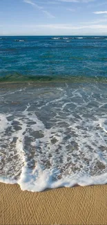 Serene beach mobile wallpaper with waves and sand.