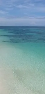 Tranquil beach with turquoise ocean and clear sky.