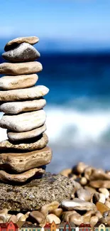 Balanced stack of pebbles on a beach with ocean in the background.