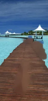 Serene beach pier with turquoise ocean under blue sky.