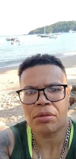 Person on a serene beach with boats and blue sky.