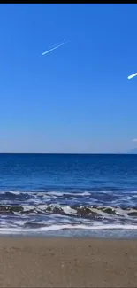 Mobile wallpaper of a serene beach with a clear blue sky.