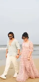 Couple walking on a serene beach together, holding hands.