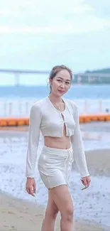 Woman walking along a serene beach coastline.