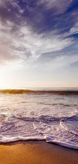 Serene beach sunrise with waves and vibrant sky in a mobile wallpaper.